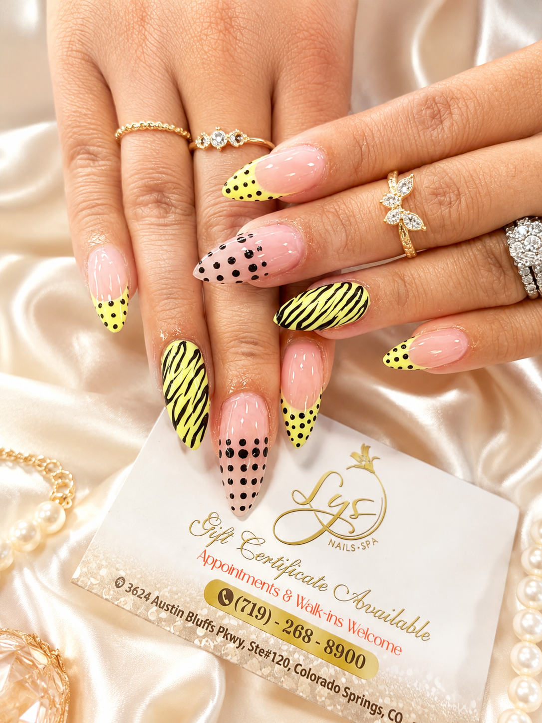 Yellow and black nail art with polka dot and zebra print accents